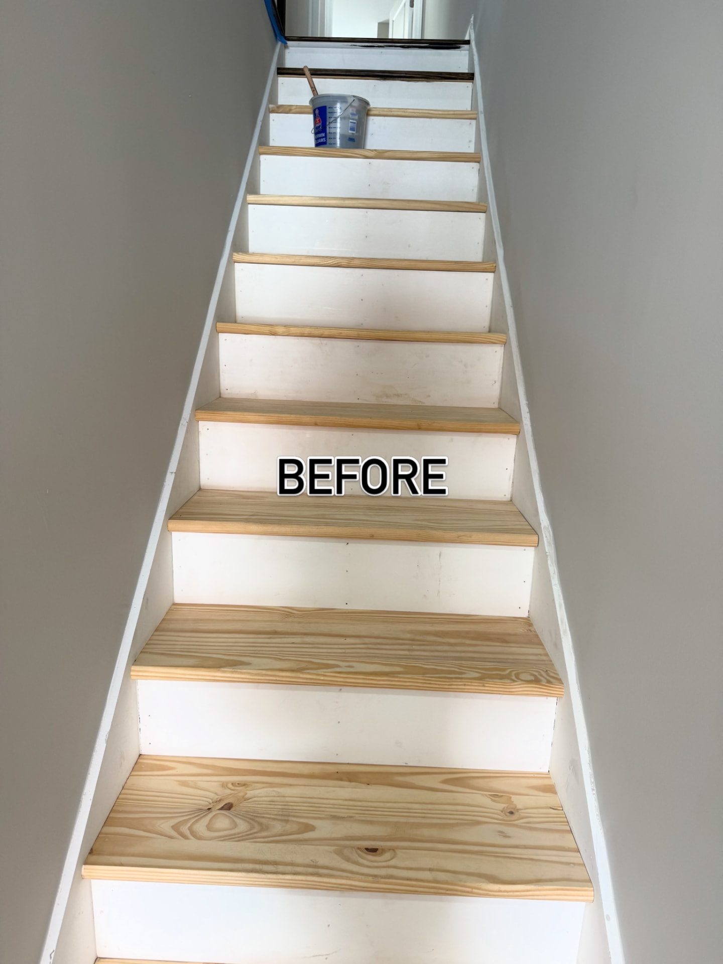Staircase before refinishing with raw pine treads and unfinished risers