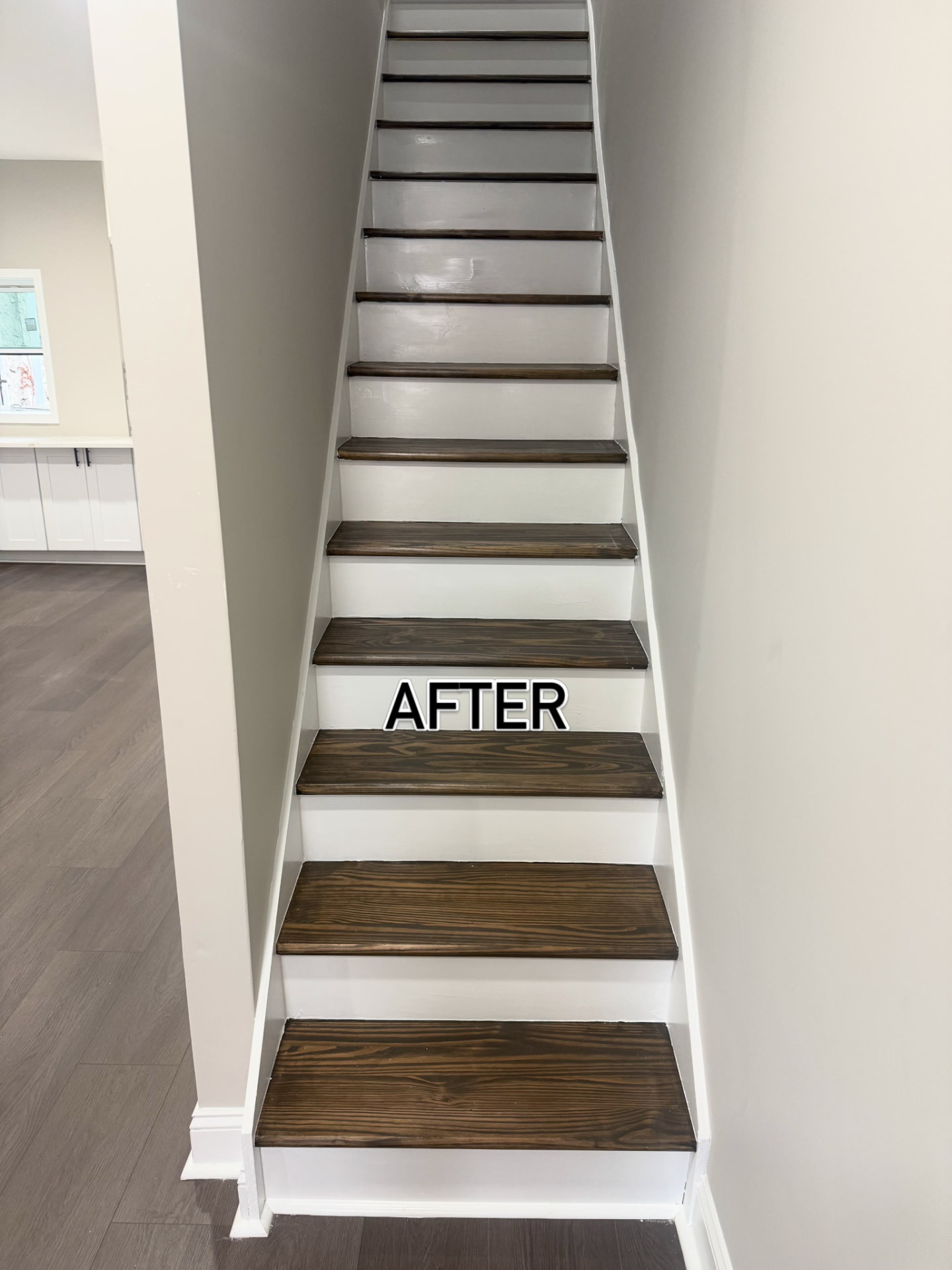 Same staircase after refinishing with dark stained treads and crisp white risers